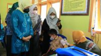 Hujan bukan halangan, Bu Dokter Hj.Hasnah Syam Tetap Turun Kelapangan Pantau Jalannya Vaksinasi Anak
